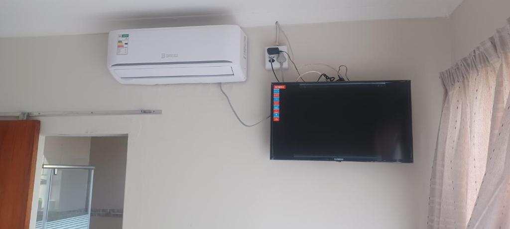 una televisione e un condizionatore a muro di Princia Guest House a Newcastle