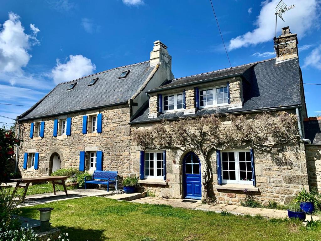 Cette ancienne maison en pierre est dotée de portes et de fenêtres bleues. dans l'établissement Belle maison bretonne, à Plouguerneau