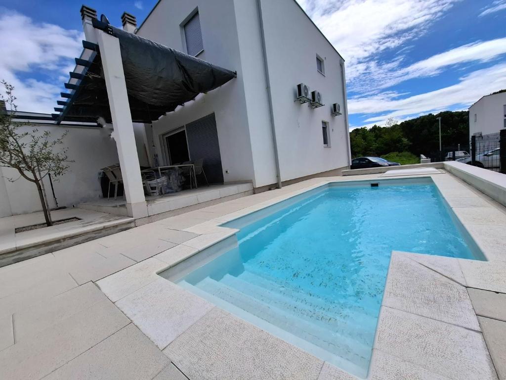 a swimming pool in front of a house at Casa Bučina in Umag