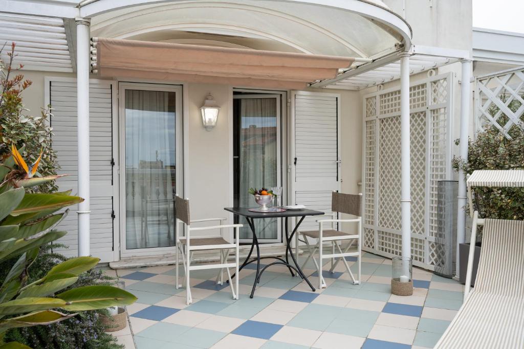 a patio with a table and chairs on a porch at Palace Hotel in Viareggio