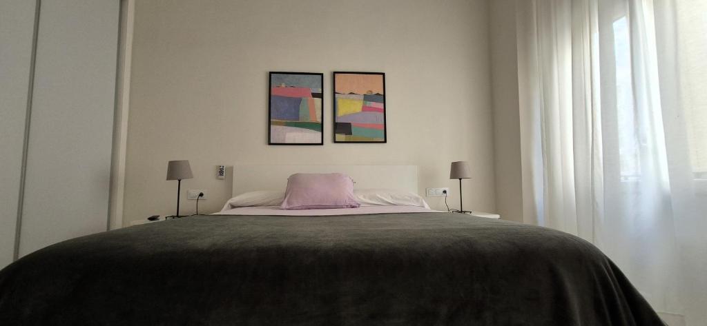 a bedroom with a bed with a pink pillow on it at La esquina de los italianos by Gades Gestión in Cádiz