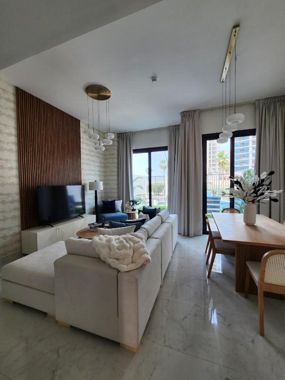 una sala de estar con un sofá y una mesa en Nasma Luxury Stays - Lakeside Retreat Stylish & Cozy Villa Stay, en Ras al Khaimah