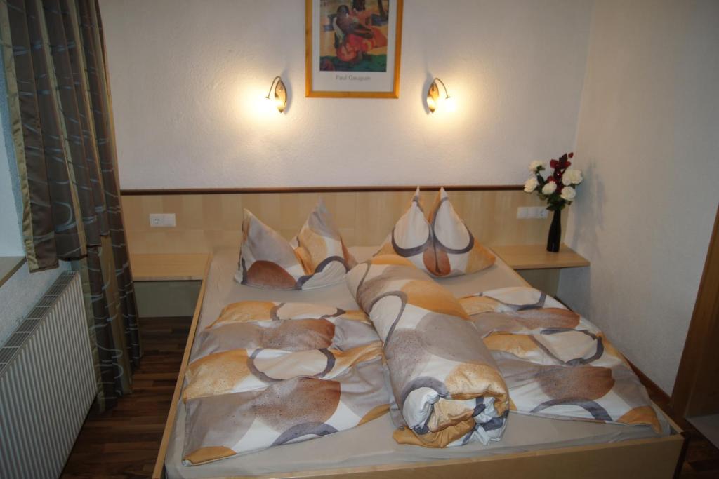 a bedroom with a bed with pillows on it at Familienferienhaus Florentine in Längenfeld