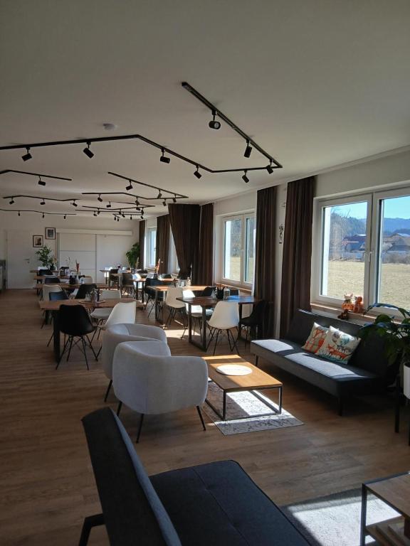 a living room with couches and tables and windows at Hotel Fuchs & Hase SELF CHECK IN in Rosegg