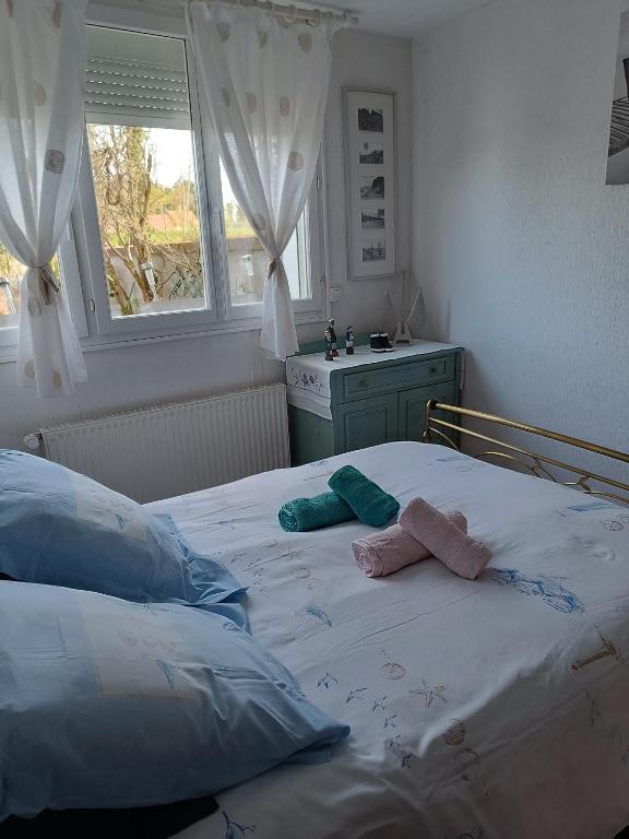 une chambre avec un lit avec deux serviettes dessus dans l'établissement gite de l amboise, à Saint-Valery-sur-Somme