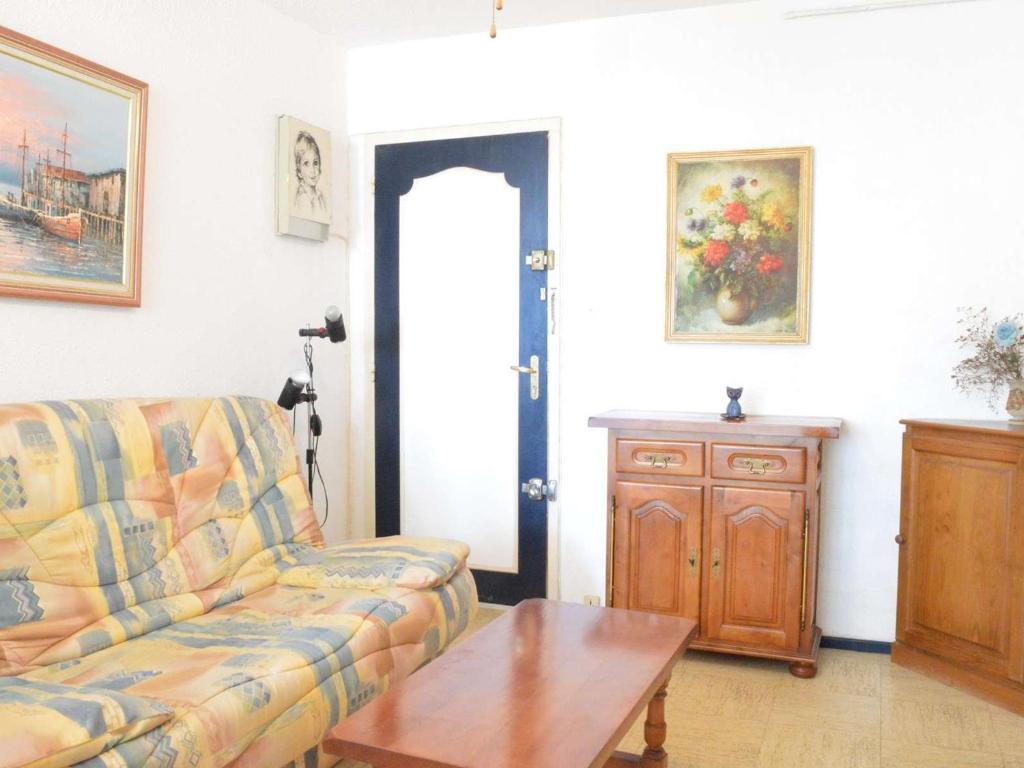 un salon avec un canapé et une table dans l'établissement Appartement Cosy Proche Mer: 2 Pièces, 4 Couchages, Narbonne Plage - FR-1-229B-19, à Narbonne-Plage