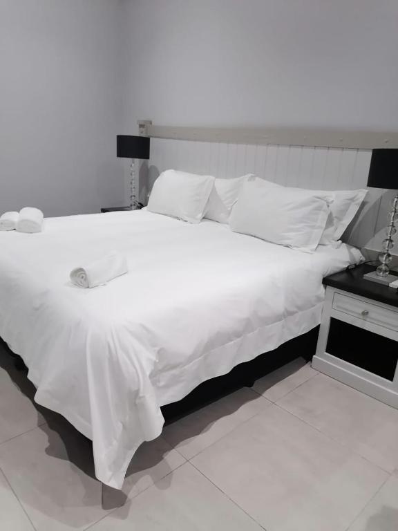 1 cama blanca grande con sábanas y almohadas blancas en Pearl Holiday homes, en Vosburg