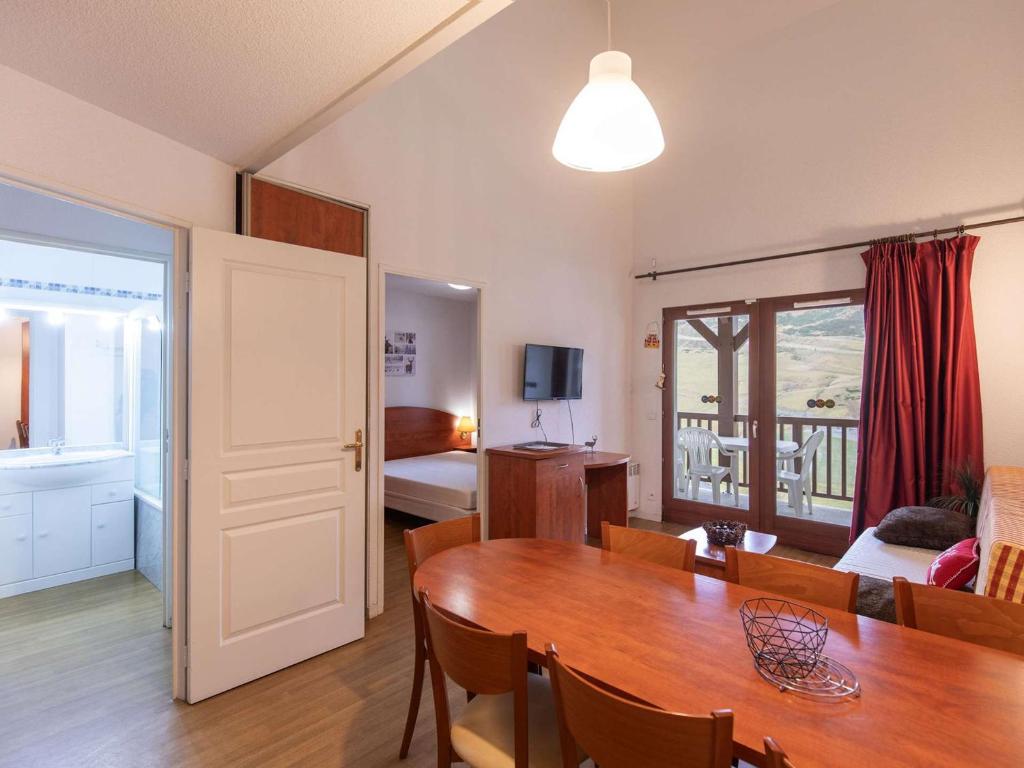 - un salon avec une table à manger et une chambre dans l'établissement Charmant Duplex T3 avec Terrasse, Piscine, Salle de Fitness et Parking à La Mongie - FR-1-404-213, à La Mongie