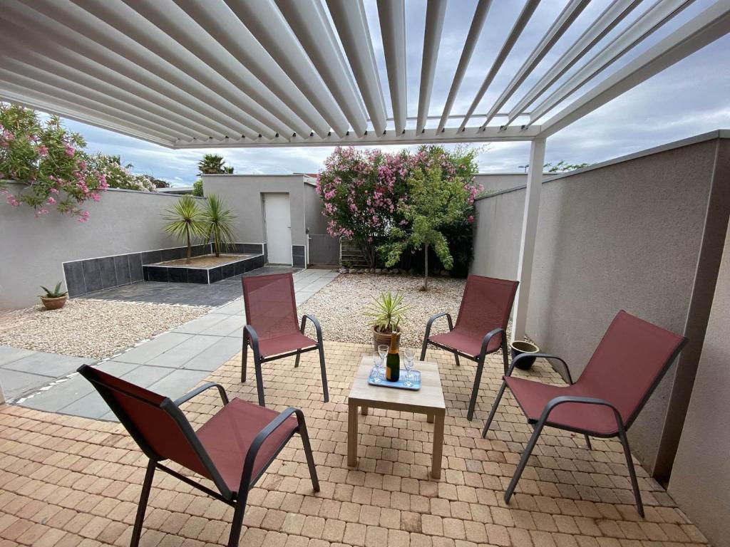d'une terrasse avec des chaises et une table sous un auvent. dans l'établissement Villa 3 Ch. avec Jardin, Piscine, Parking et Plage à 400m – Sète - FR-1-472-151, à Sète