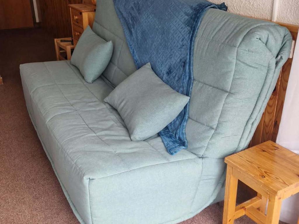 - un canapé avec deux oreillers à côté d'une table dans l'établissement Studio 3 pers. 2* avec balcon exposé Ouest, centre Valloire, parking privé, animaux acceptés - FR-1-263-491, à Valloire