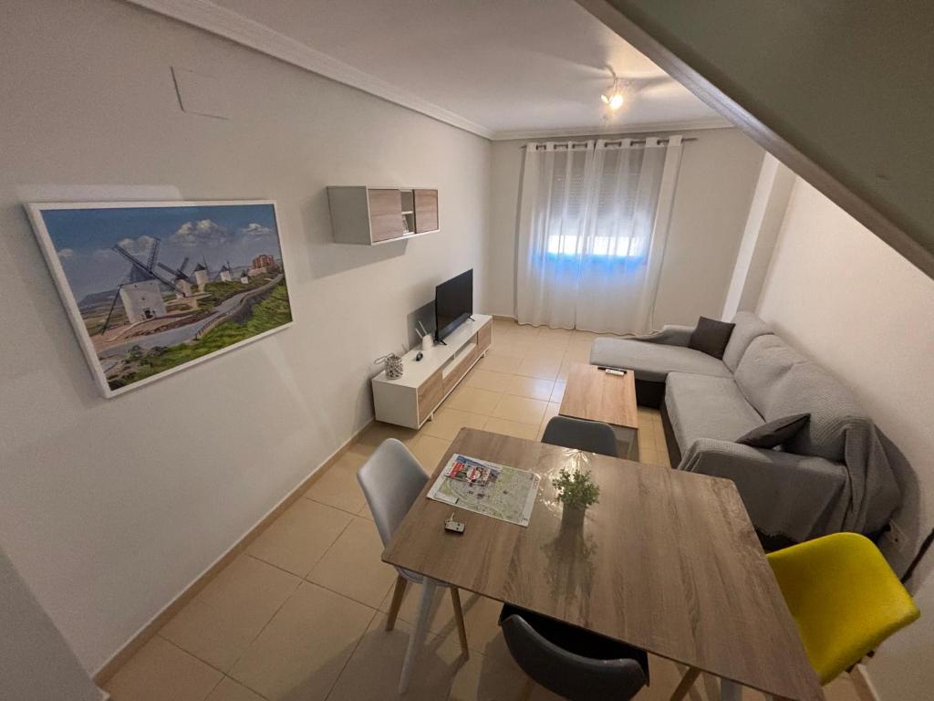 a living room with a table and a couch at Duplex entre molinos Consuegra in Consuegra
