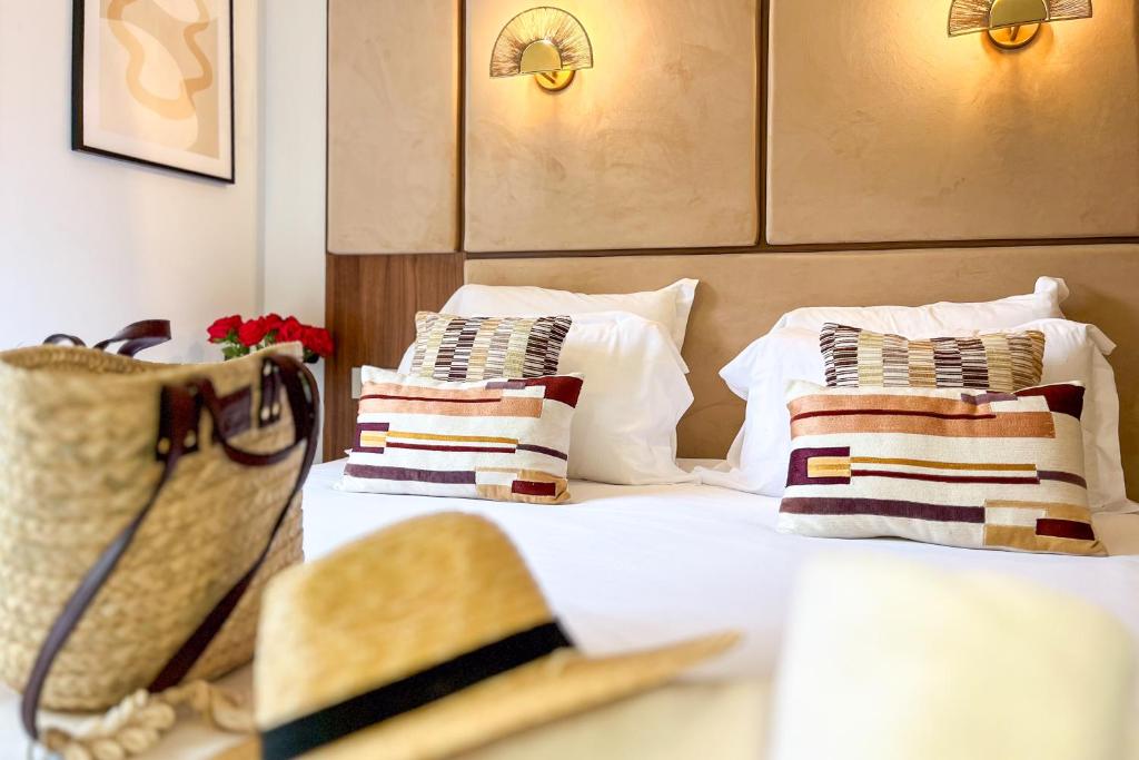 a hotel room with two beds with pillows and a purse at Studio Place des Lices - K1 in Saint-Tropez