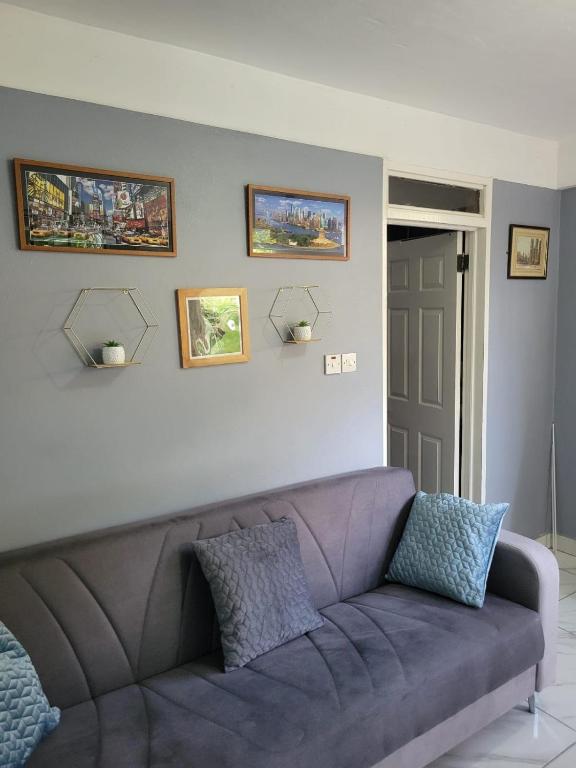 - un canapé dans le salon avec des photos sur le mur dans l'établissement Hidden gem in Massacre Dominica, à Massacre