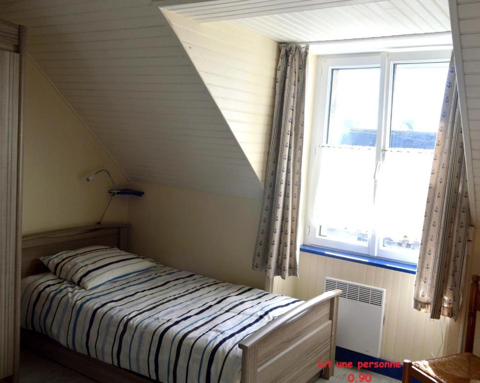 a bedroom with a bed and a window at PentyTy TadKozh Très proche du port de Kérity in Penmarcʼh