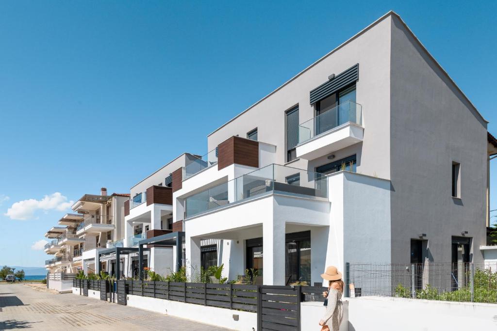 a woman standing in front of a white building at Kleoniki Residential Complex in Ofrínion
