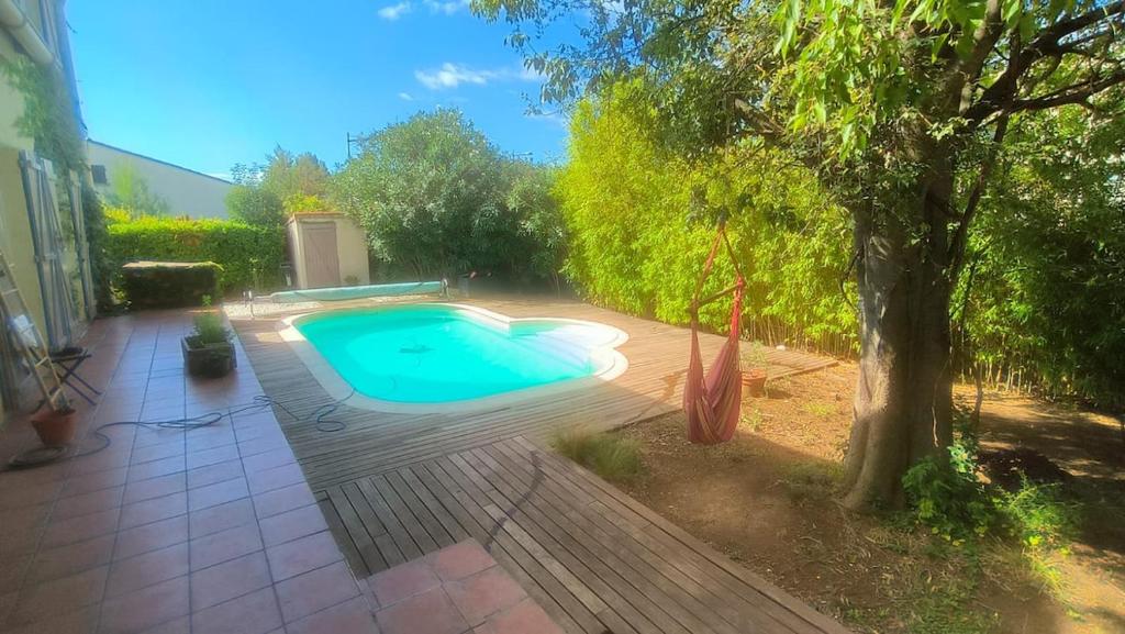 - une piscine dans une cour avec un arbre dans l'établissement Maison avec piscine privative aux beaux arts a montpellier, à Montpellier