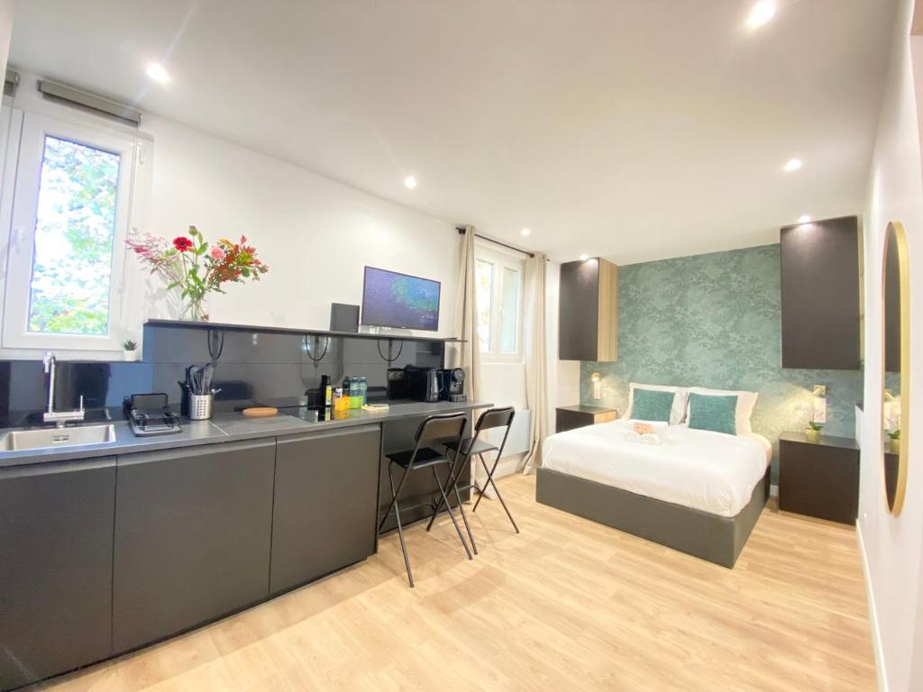 une cuisine et une chambre avec un lit dans une pièce dans l'établissement GuestReady - Sleek emerald escape in the 13th arr., à Paris
