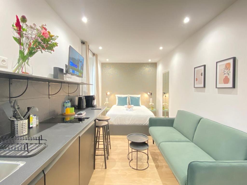 - une cuisine avec un canapé et un lit dans une chambre dans l'établissement GuestReady - Cozy green haven in Paris 13, à Paris