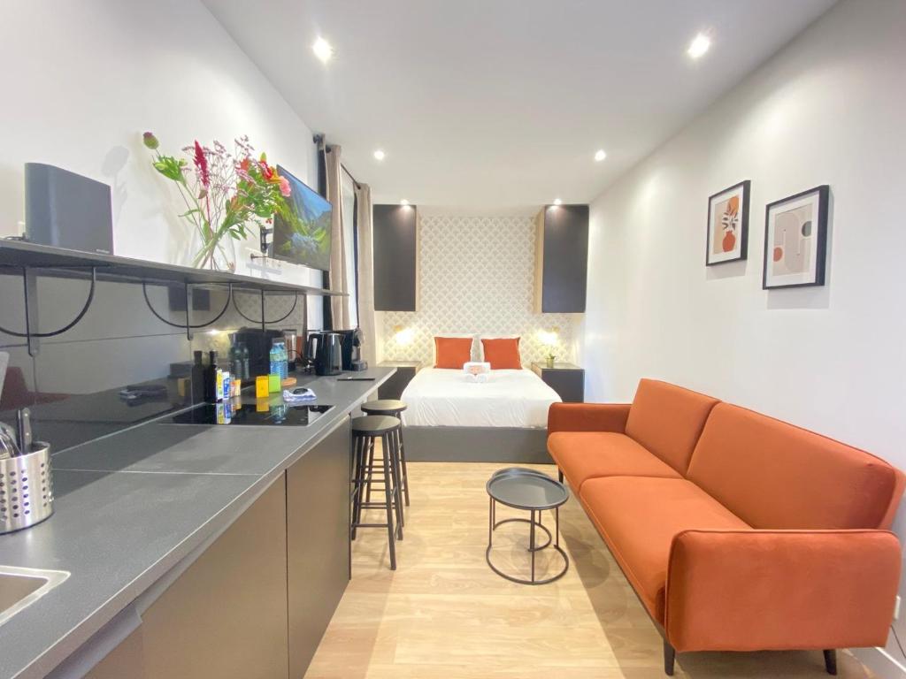 - une cuisine avec un canapé et un lit dans une chambre dans l'établissement GuestReady - Warm and Stylish Nest in the 13th, à Paris
