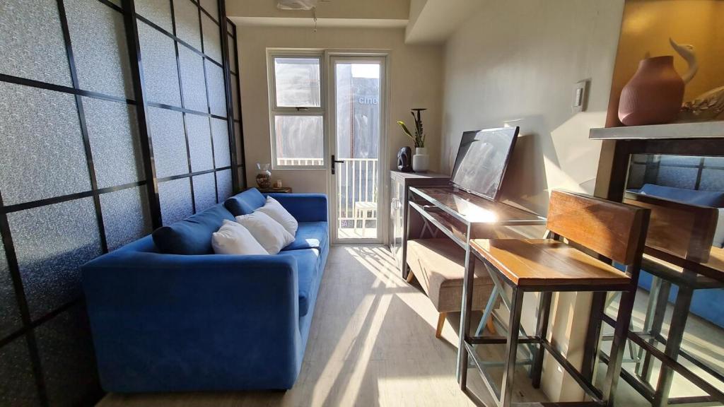 a living room with a blue couch and a table at Capitol Central Condo, 2 Bedroom in Bacolod