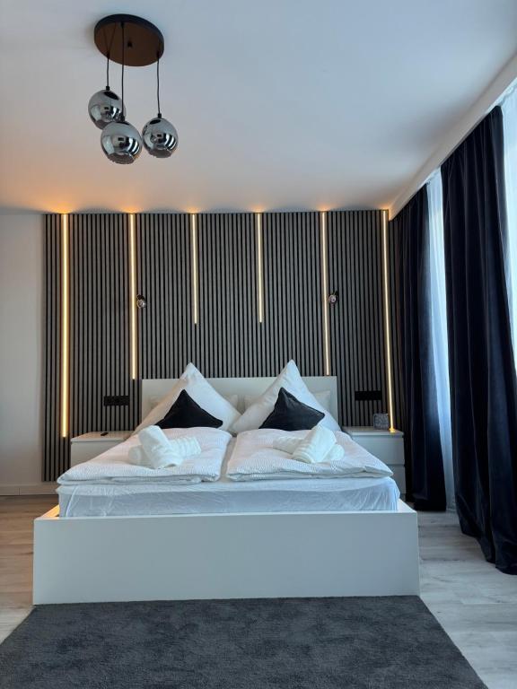 a bedroom with a white bed with black curtains at Atlantic 003- Exclusive Ferienwohnung mit Pool, Sauna und Fitnessbereich im Haus in Cuxhaven