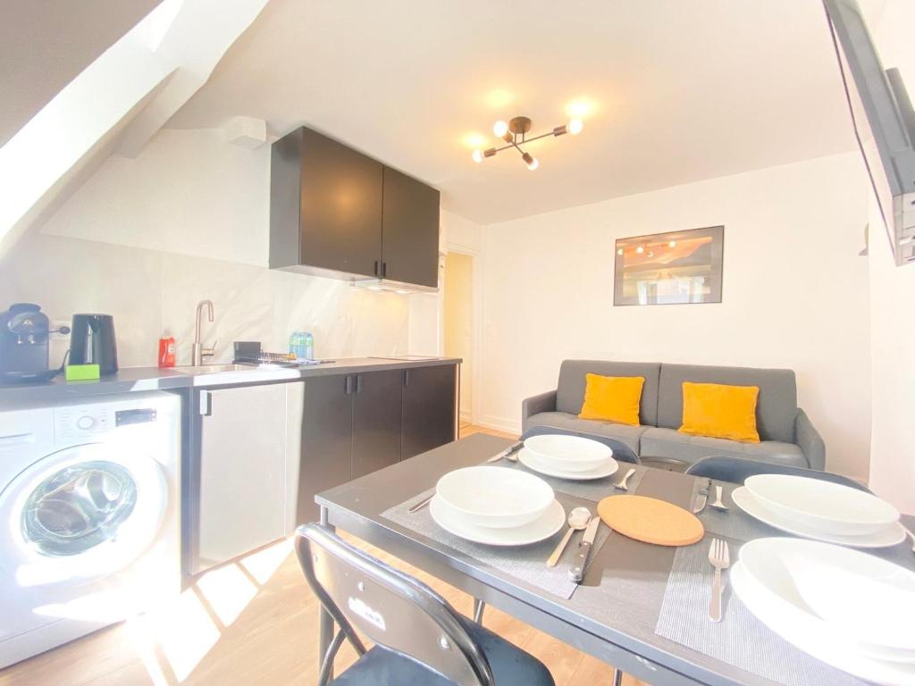 une cuisine et un salon avec une table et un canapé dans l'établissement GuestReady - Cozy nest in Salpêtrière, à Paris