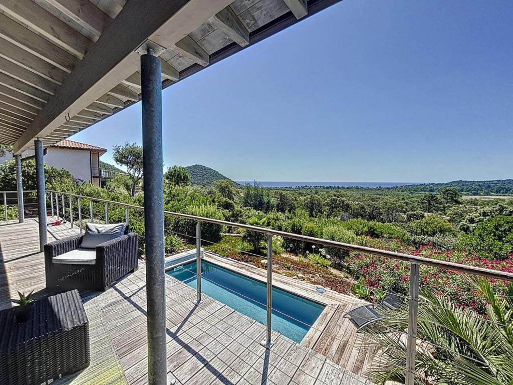 une maison avec un balcon et une piscine dans l'établissement Villa Dalenassara, 14 pers, piscine chauffée, 2 min plage en voiture, à Olmucciu
