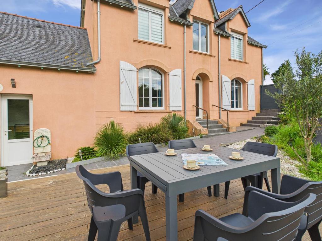 un patio avec une table et des chaises devant une maison dans l'établissement Jolie maison avec jardin et terrasse pour 4, à Fouesnant