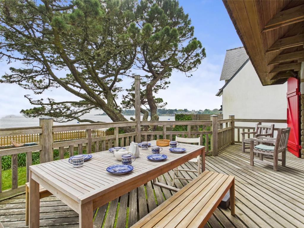 a wooden deck with a wooden table and a bench at Grande maison vue mer et acces plage direct pour 7 in Bénodet