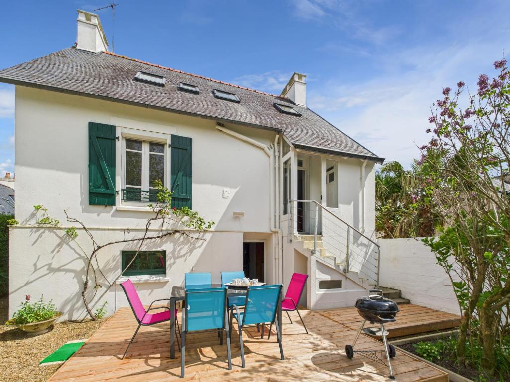 un patio avec des chaises et une table devant une maison dans l'établissement Maison à 30m de la plage - Grand Jardin - pour 6, à l'Île-Tudy