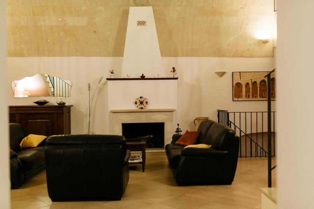 Residence Del Casalnuovo في ماتيرا: غرفة معيشة مع كرسيين ومدفأة