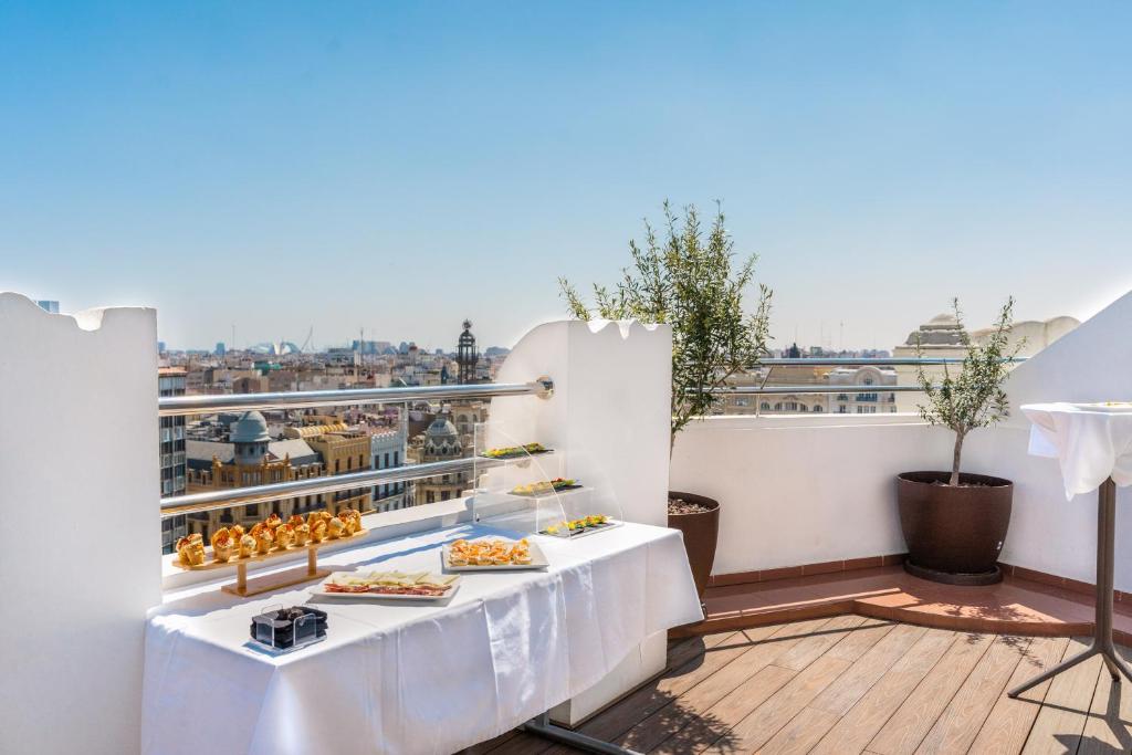 a balcony with a table with food on it at Melia Plaza Valencia in Valencia