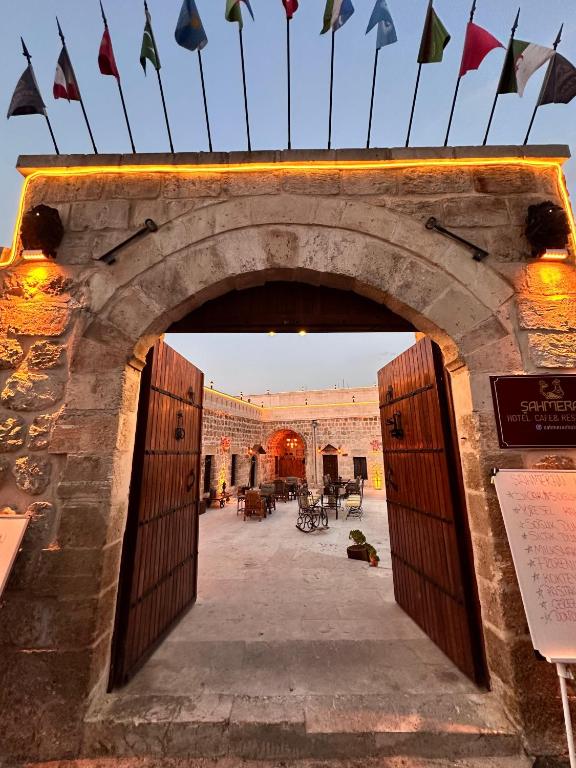 an entrance to a building with an arch with flags at ŞAHMERAN OTEL & Cafe in Midyat