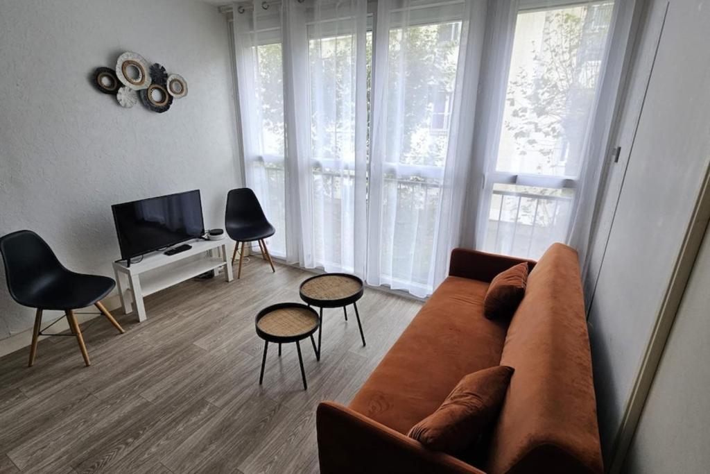 - un salon avec un canapé, deux chaises et une télévision dans l'établissement Appartement spacieux F5 au Havre, au Havre