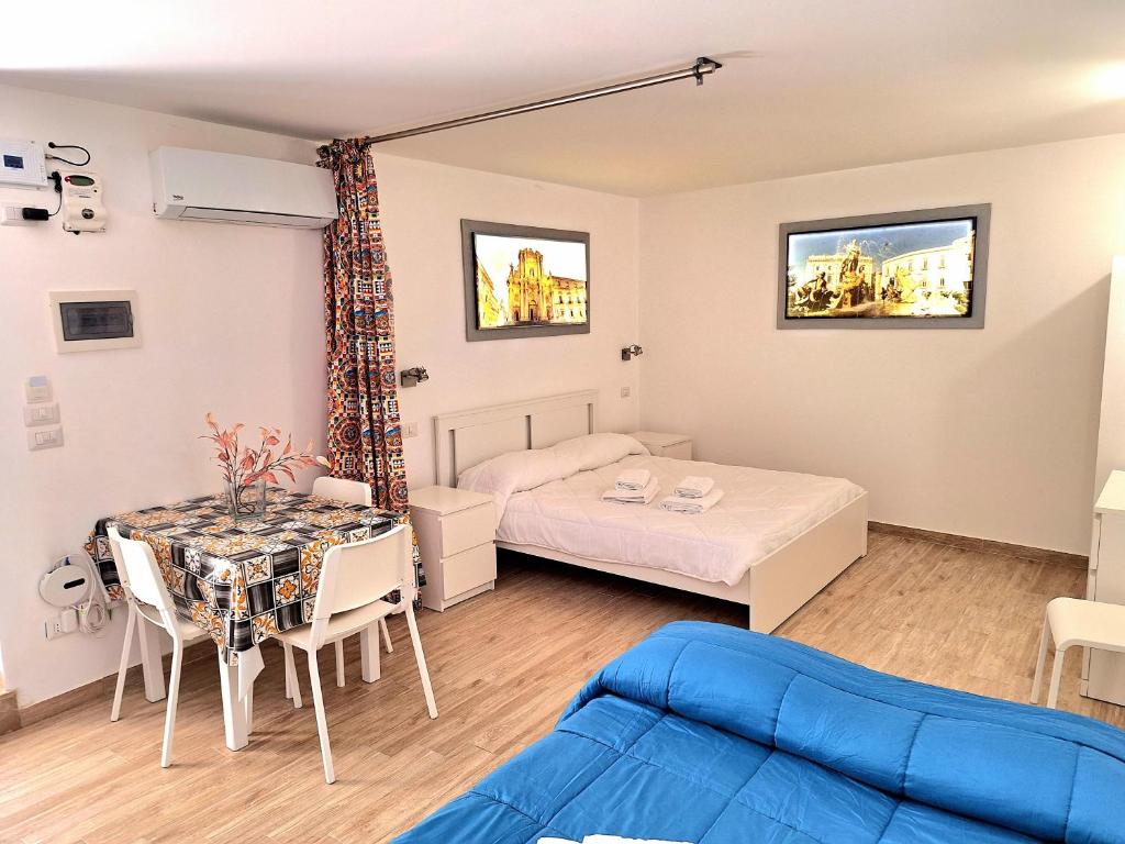 a room with a bed and a table and a couch at Nata Sicula in Syracuse