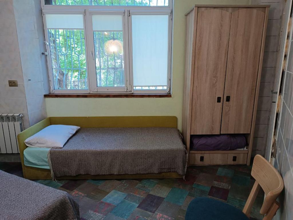 a small bedroom with a bed and a window at Номер в доме у моря с бассейном in Odesa