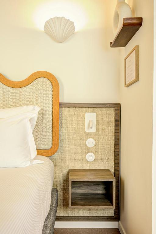 a hotel room with a bed and a nightstand next to a bed sidx sidx at Hôtel Gabriel in Menton