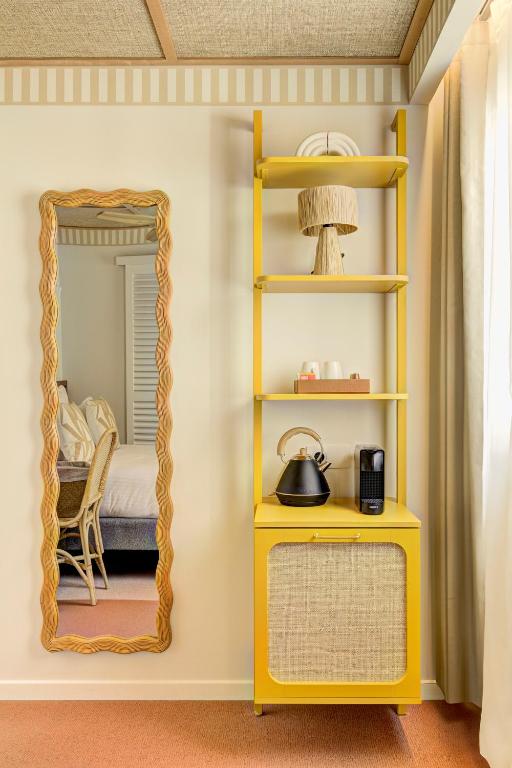 a yellow shelf in a room with a mirror at Hôtel Gabriel in Menton