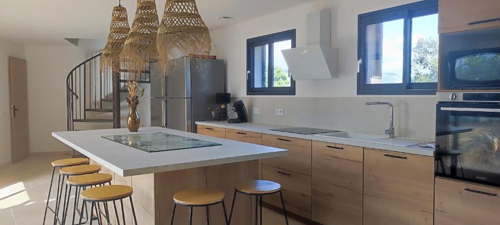 une cuisine avec un grand îlot et des tabourets de bar dans l'établissement Fior di Lucia, à Zonza