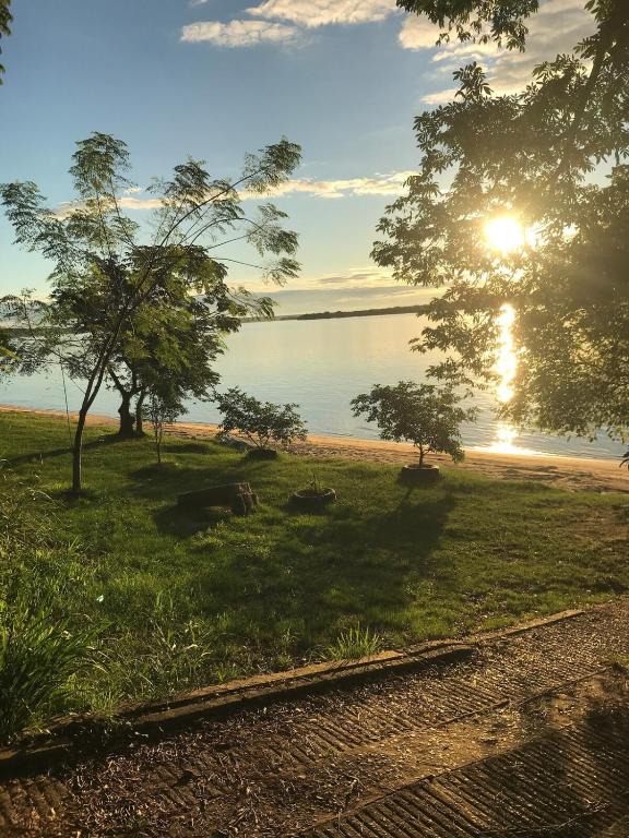 a view of a beach with trees and the sunset at Cabaña Conectar Naturaleza in Ituzaingó