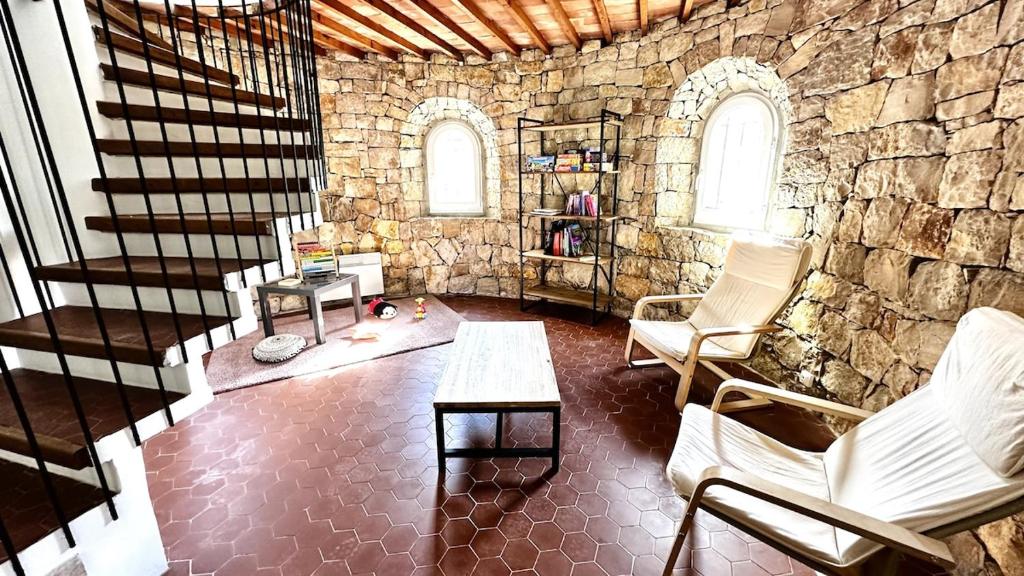- un salon avec un mur en pierre et des escaliers dans l'établissement Maison Campagne Aixoise, à Ventabren