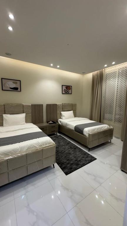 two beds in a large room with two beds sidx sidx sidx at شقق الستين بارك in Khamis Mushayt
