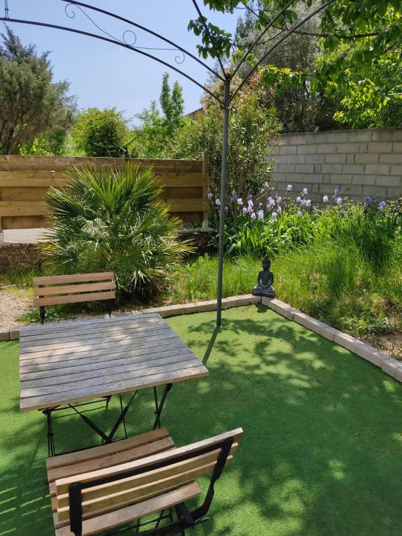 a picnic table and a bench in a garden at appartement indépendant f2 avec terrasse et jardin in Cannes-et-Clairan