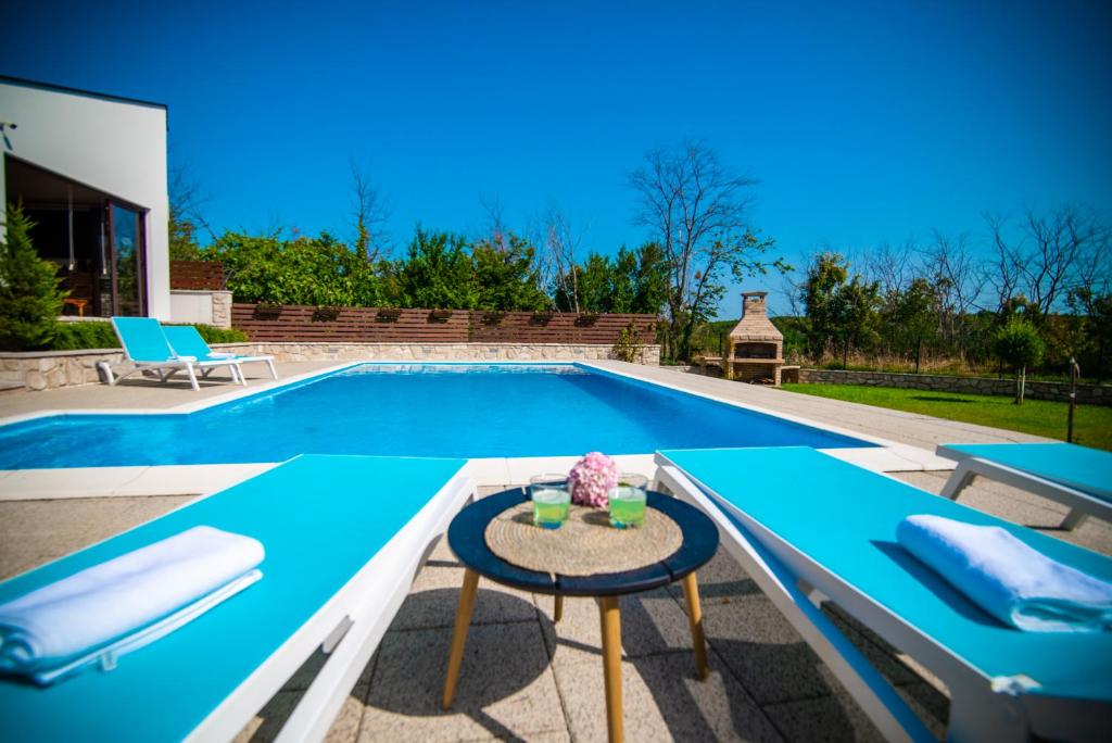 a swimming pool with a table in front of it at Villa Tia in Mostar
