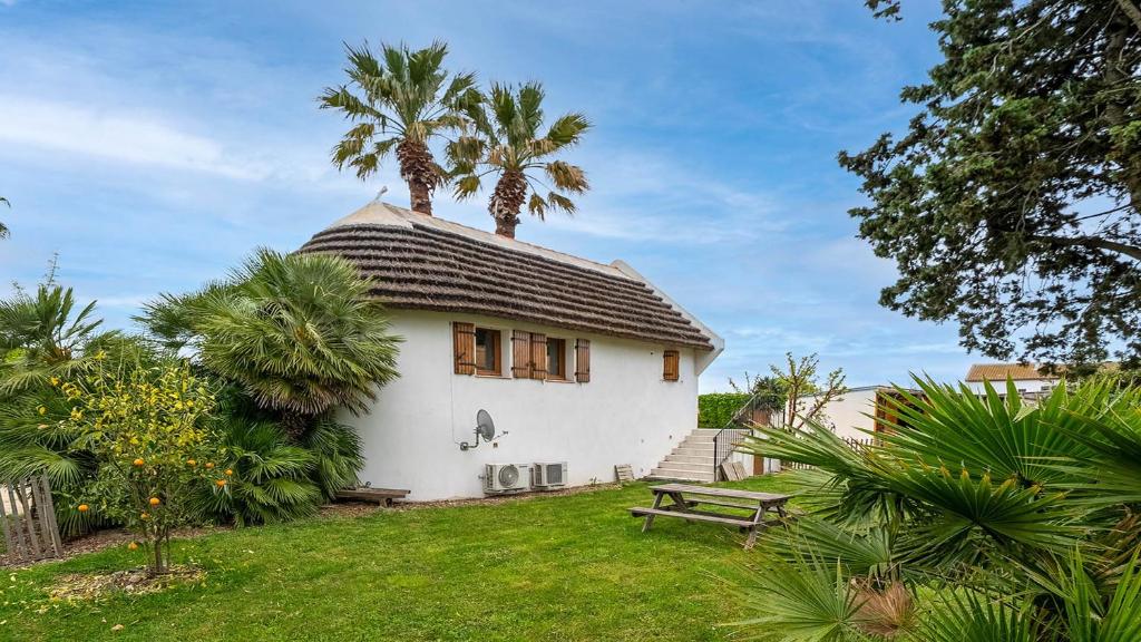 une maison blanche avec deux palmiers au sommet dans l'établissement El Rancho - ST4 Mezzanine, au Grau-du-Roi