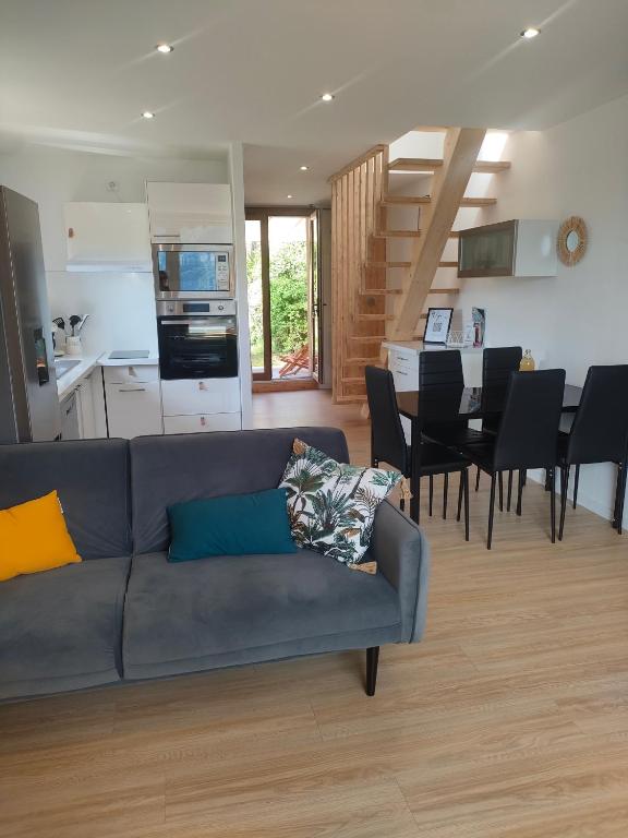 a living room with a couch and a dining room and kitchen at Le Duplex du Plongeoir - spacieux T3 de 65m2 avec vue sur le lac de Serre Ponçon in Savines
