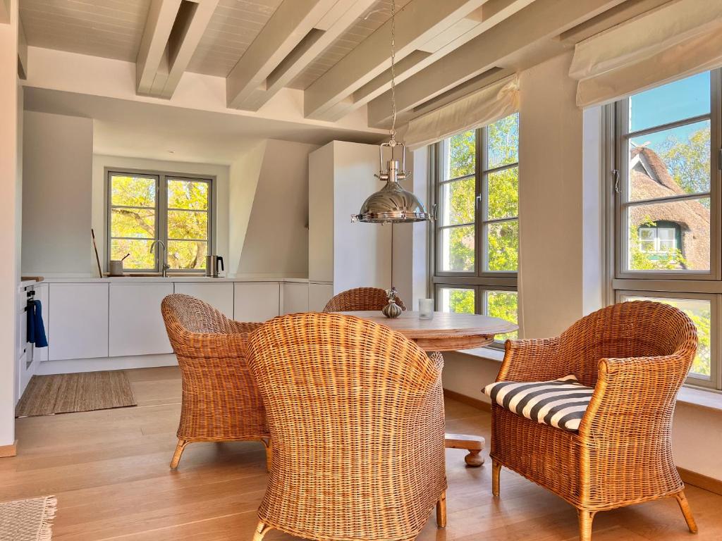 Una cocina con mesa y sillas y ventanas. en Sommerby Sky, en Brodersby