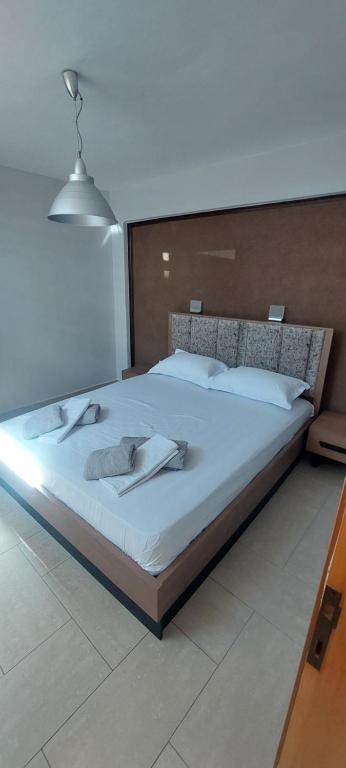 a bedroom with a large bed with white sheets at Petrino 2 semibased by Vasileia in Sarti
