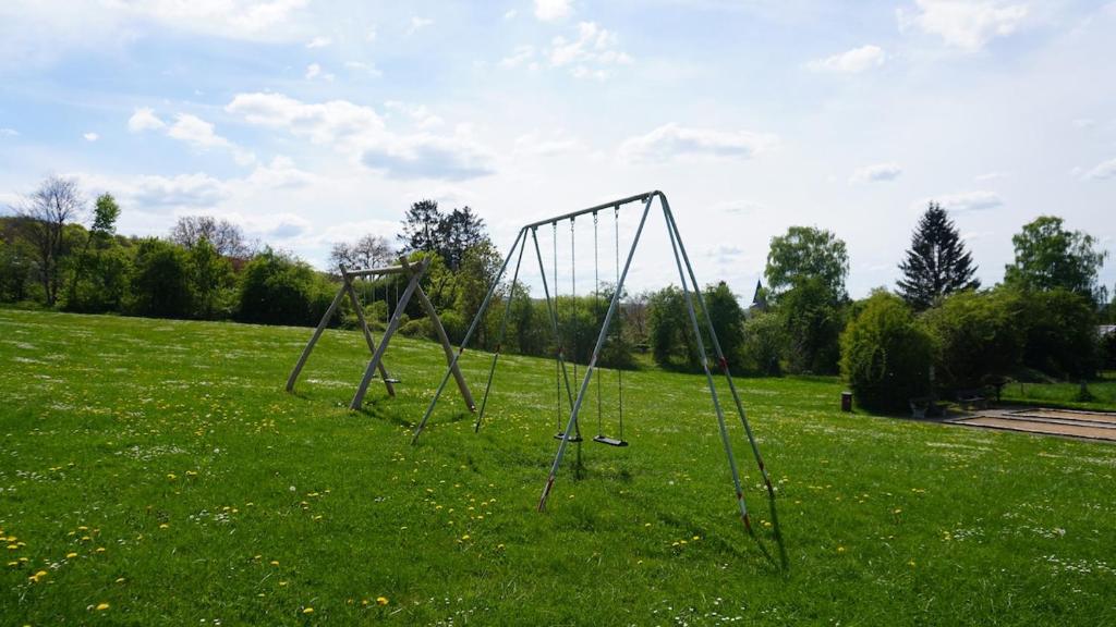 an empty swing set in a field of grass at Cocoon Ny II - DURBUY in Hotton