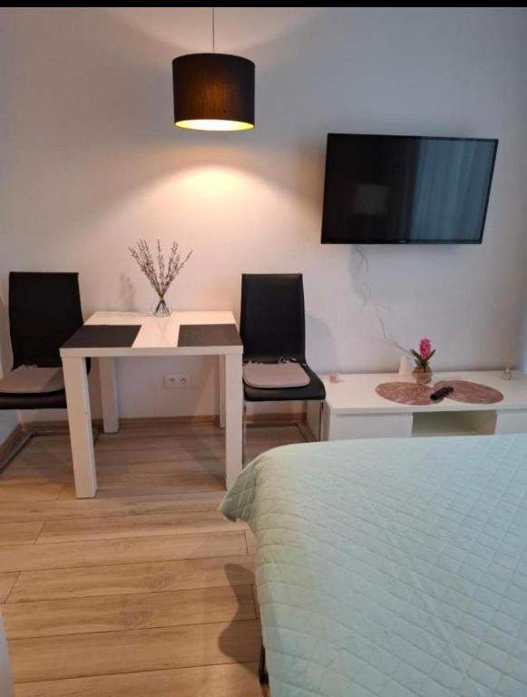 a room with a table and two chairs and a tv at Zlatarooms 409 in Warsaw